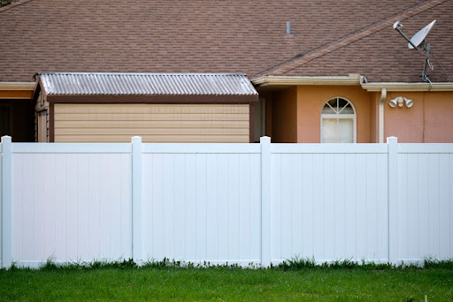 White plastic fence for back yard protection and privacy.